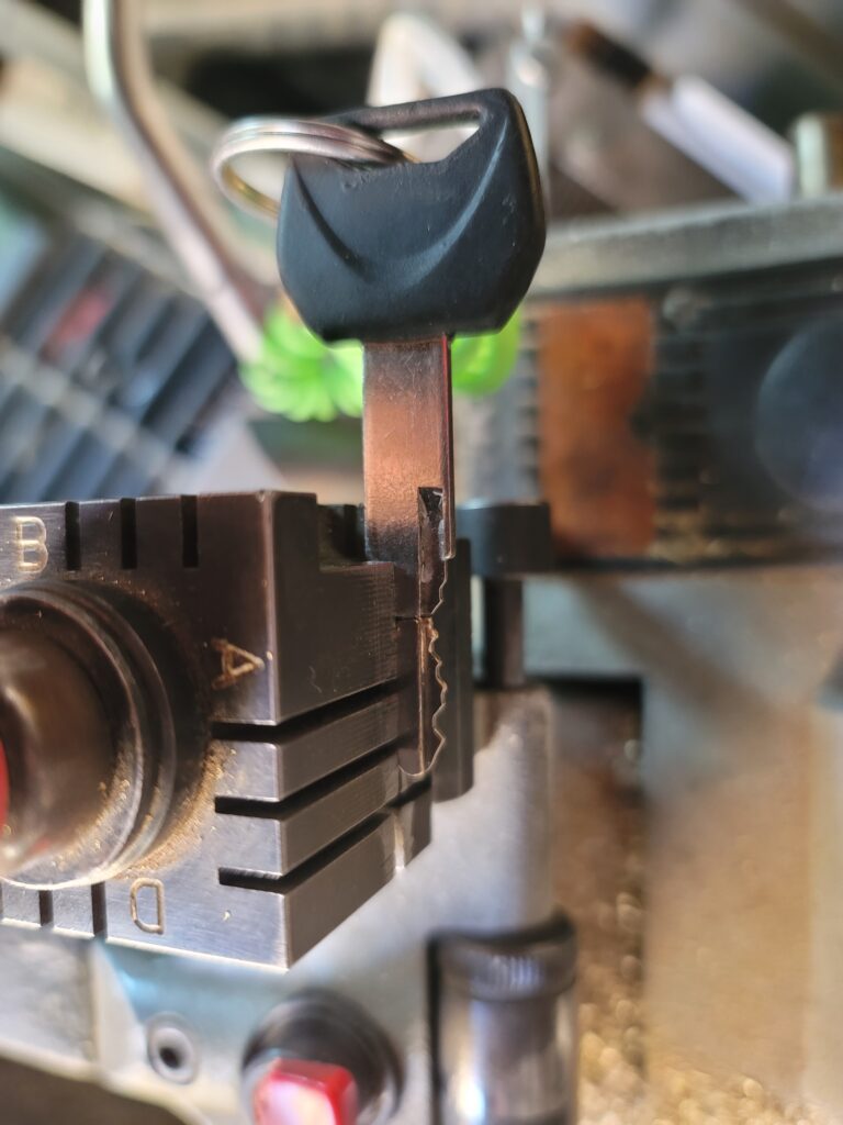 Key being cut in a key duplicating machine. Close-up of the key and cutting mechanism. Turn Key Locksmith, Phoenix AZ