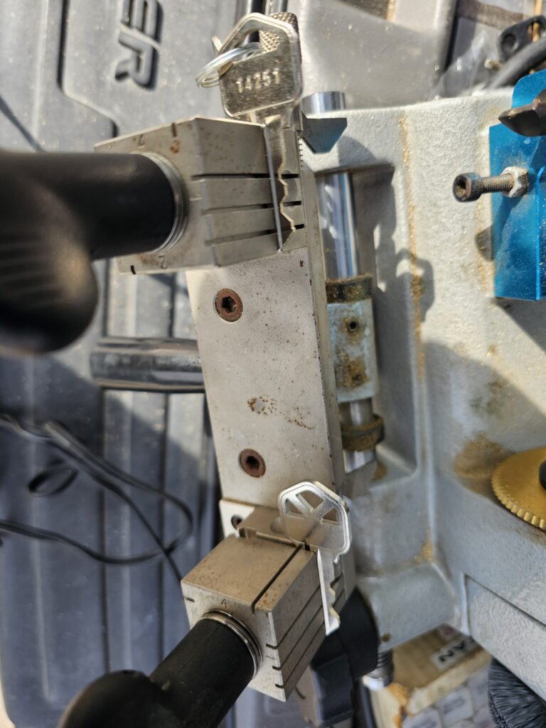 Key duplication machine with a key in each clamp. Turn Key Locksmith, Phoenix AZ